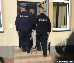 policjanci prowadzą zatrzymanego mężczyznę