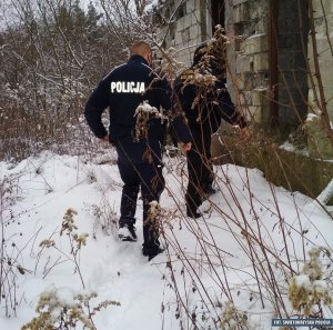 Zdjęcie przedstawiające policjanta i strażnika miejskiego podczas sprawdzenia pustostanu