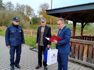 policjant i burmistrz gratulują mężczyźnie