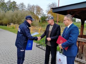 policjant i burmistrz gratulują mężczyźnie